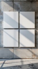 a mockup blank white canvases hang side by side on a concrete wall, illuminated by soft light casting subtle shadows
