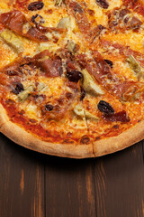 Pizza with tomato sauce, mixed cheese selection, ham, pepperoni, bacon, fresh mushrooms and olives.
