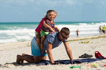 dad with children, playing with kids, family on the beach, swimming in the ocean, vacations in warm...
