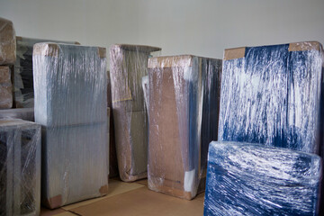 Different parts of the furniture are wrapped in a protective film when disassembled, ready for transportation. A transparent film covers the upholstered parts of furniture for transportation