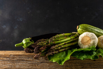 View of fresh asparagus with vegetables on wooden rustic table. Food background.
