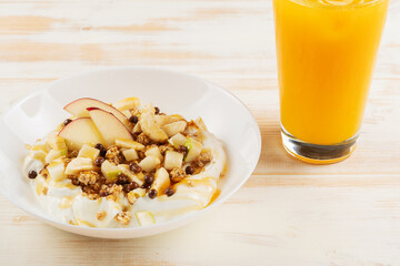 Healthy Βreakfast concept. Yogurt with flakes, fruits and honey on wooden background.