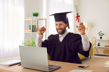 Distance home graduation ceremony, happy adult male student at laptop wearing cap and gown getting...