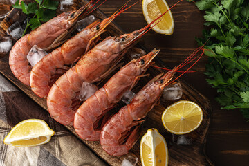 Fresh shrimps on wooden background with lemon slice. Seafood background.