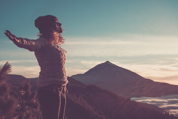 Happy free woman open arms and enjoy the amazing beautiful sunset at the mountain - active people...