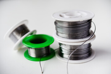 Tin-lead solder in coils on a white background. Materials for soldering.