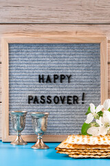 Happy Passover. Metal wine glasses and traditional Jewish matzo bread.