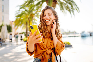 Young caucasian woman smiling happy using smartphone at the city.  Technology, blogging, travel,...