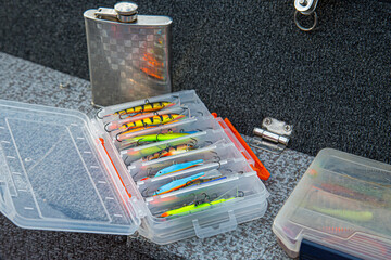 Fishing tackles and fishing baits in box .Classic Colored Fishing Lure , Beautiful Background digital image.Fishing on the lake at sunset.