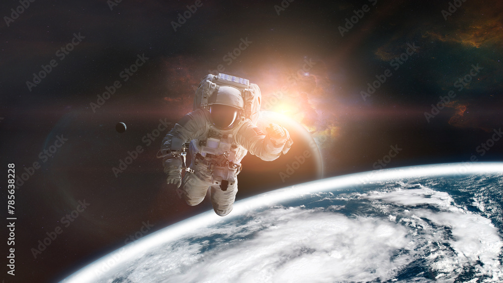 Wall mural astronaut in outer space on low-orbit of earth planet with sunlight. elements of this image furnishe