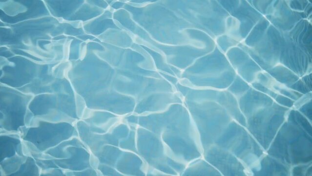 Slow motion video of pool water with sunlight reflections moving throughout the frame