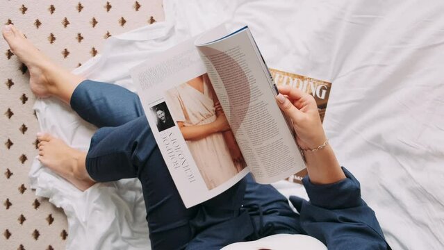 girl leafing through a magazine turning pages