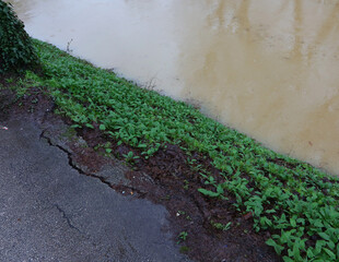 collapsed  asphalt of road and has large cracks due to rising floodwaters after rain - 785641428