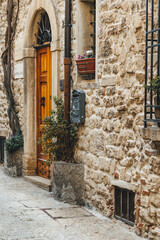 Fototapeta na wymiar narrow street in the city of san marino with stone wall and vegetation