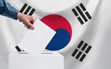 Elections, South Korea. The concept of elections. A hand throws a ballot into the ballot box. The...