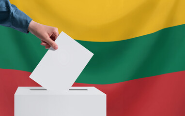 Elections, Lithuania. A hand throws a ballot into the ballot box. The flag of Lithuania on the background. The concept of voting.