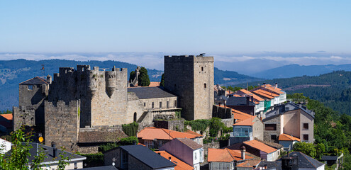Vista panorámica del castillo de Castrocaldelas en el pueblo de Orense, con tejados y montañas al...