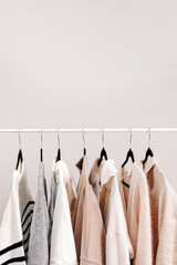 Beige and white colored wardrobe, female clothing on the hangers