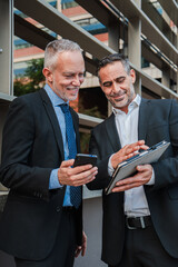 Vertical. Two professional colleagues suited up and engrossed, collaborate as they navigate data...