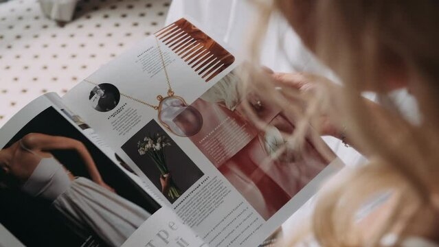 girl leafing through a magazine turning pages