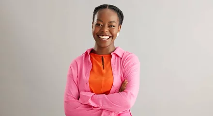  Black woman, arms crossed and portrait with smile in studio for fashion, confidence and pride on grey background. African person, happy and face of person with trendy, style and positive mindset © peopleimages.com