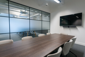Modern conference room with a large table and screen