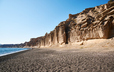 Vlychada beach on the southern tip of the island of Santorini with high white cliffs carved in...