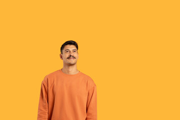 Millennial guy with moustache on orange backdrop