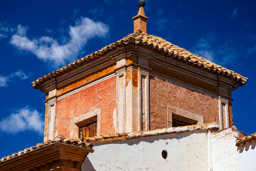 Detail of old tower with windows of house in the old neighborhood of Caravaca, Murcia, Spain over blue sky