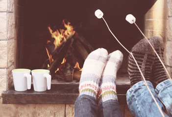 Feet of the couple warming at a fireplace