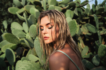 Portrait of woman against vibrant greenery of the prickly pear cactus surroundings