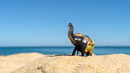 figurine of an elephant on the beach sunbathing