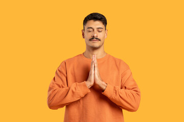 Man with moustache in prayer pose on orange