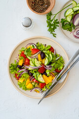 Plate of fresh salad with vegetables on white rustic background