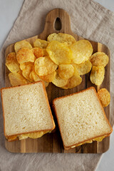 Homemade Egg Salad Sandwich with Potato Chips on a wooden board, top view. - 785668203