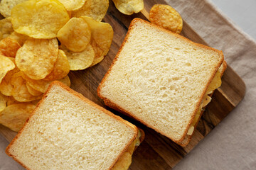 Homemade Egg Salad Sandwich with Potato Chips on a wooden board, top view. - 785668236