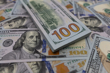Pile of US 100 dollar banknotes on dollars background