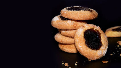 column of Argentinian traditional quince jam cookies on a black background. Horizontal and copy...