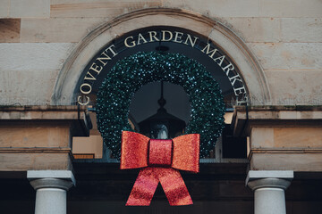 Close up of a Christmas wreath decorations on the facade of Covent Garden Market, London, UK.