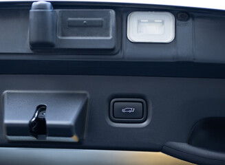Button for automatic electric opening and closing of trunk door of new passenger car. Car trunk lid open button for locking or unlocking. Automatically opening and closing the trunk