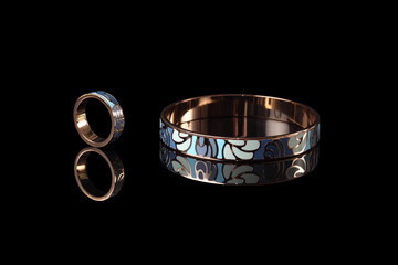 Beautiful jewelry bracelet and ring with enamel isolated on a black background.