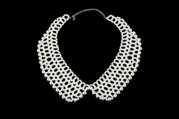A necklace made of pearl beads isolated on a black background, close-up.