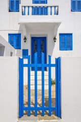 Greek whitewashed house with blue gate in Nikia village on Nisyros island. Greece