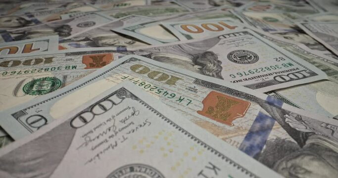 Close-up of hundred dollar bills scattered chaotically. Lot of cash American dollars lie on surface. Dollars, cash hundred dollar bills are visible, ideal image for cash investments and making profits