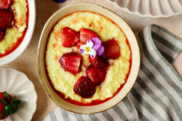 Creamy millet porridge with baked strawberries in to the bowl - 785683839