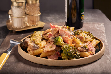 Italian styled bacon and mushroom pasta in a rustic setting.
