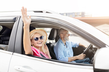 Excited elderly woman cheering in a car