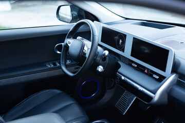 Prestige electric car. Inside car interior with front leather seats, steering wheel, windows,...
