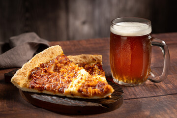 Slices of pizza with glass of beer on the table.