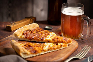 Slices of pizza with glass of beer on the table.